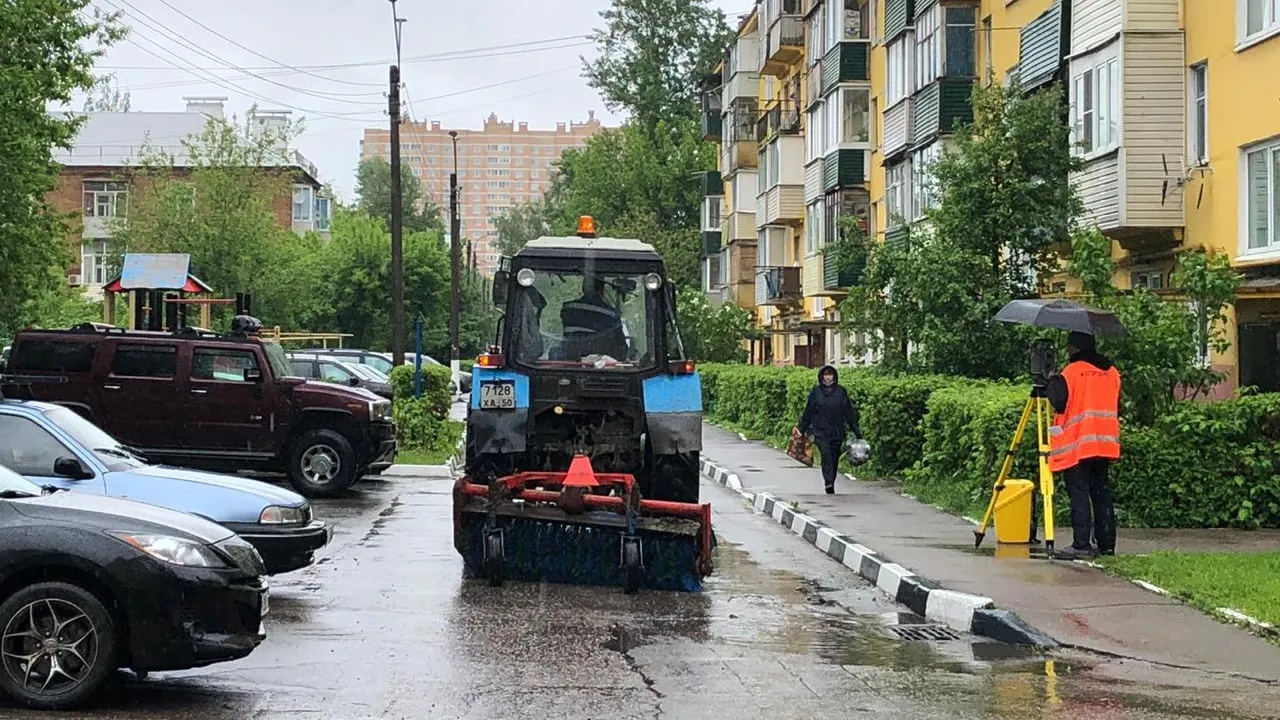 Сотрудники УК Подольска продолжают уборку дворовых территорий, несмотря на непогоду