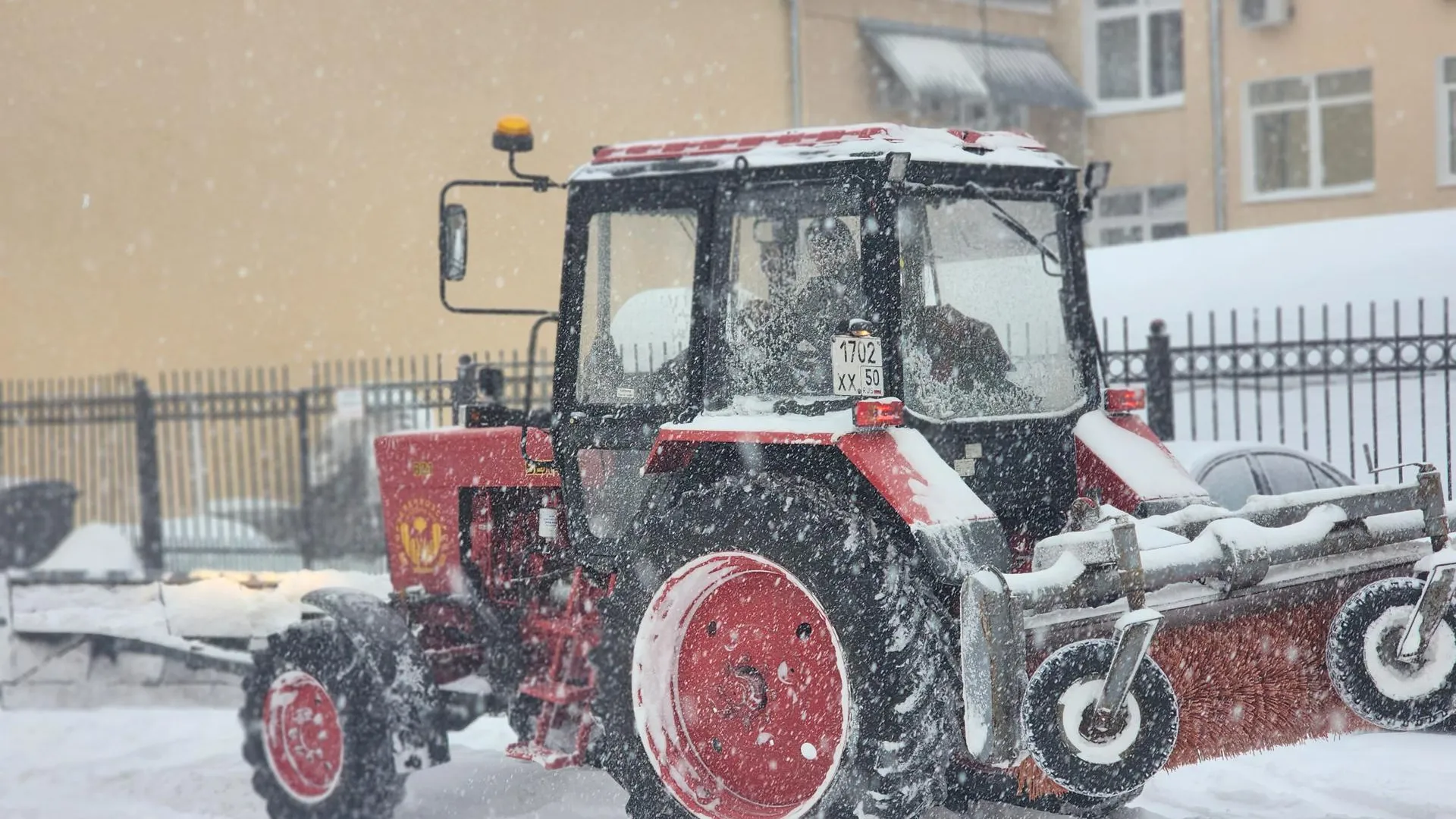 Два трактора и погрузчик освобождают от снежного плена улицу Терешковой рядом с хоровой школой в Королеве