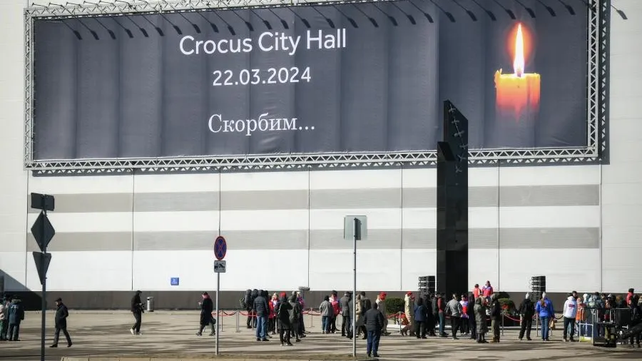 Люди несут цветы к «Крокус Сити Холлу» в годовщину теракта