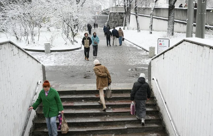 Пешеходы у метро "Авиамоторная" в Москве после выпавшего ночного снегопада.