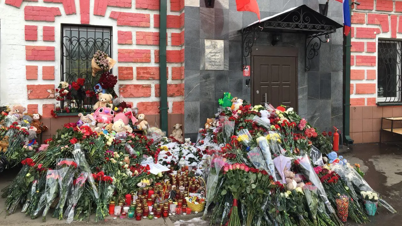 К зданию представительства Кемеровской области в Москве люди несут цветы и игрушки